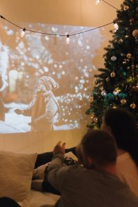 Christmas films showing on projector with Christmas tree